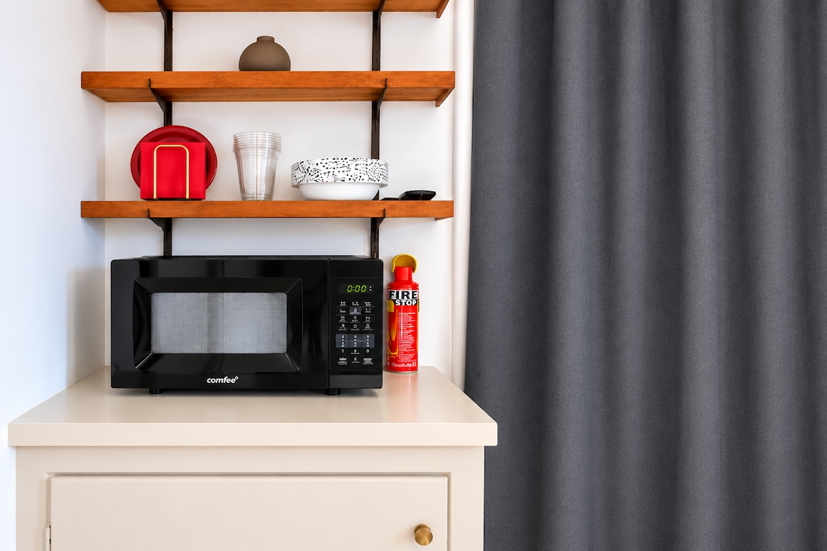 Kitchenette microwave and open shelves in the garden studio